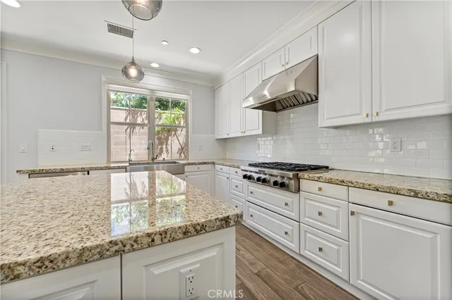 a kitchen with granite countertop white cabinets and a large window