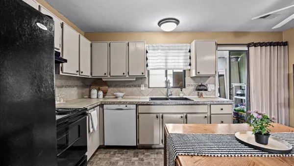a kitchen with stainless steel appliances a sink a stove a refrigerator cabinets and a window