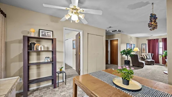 a view of a dining room with furniture and a chandelier fan