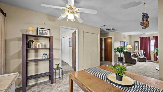 a view of a dining room with furniture and a chandelier fan