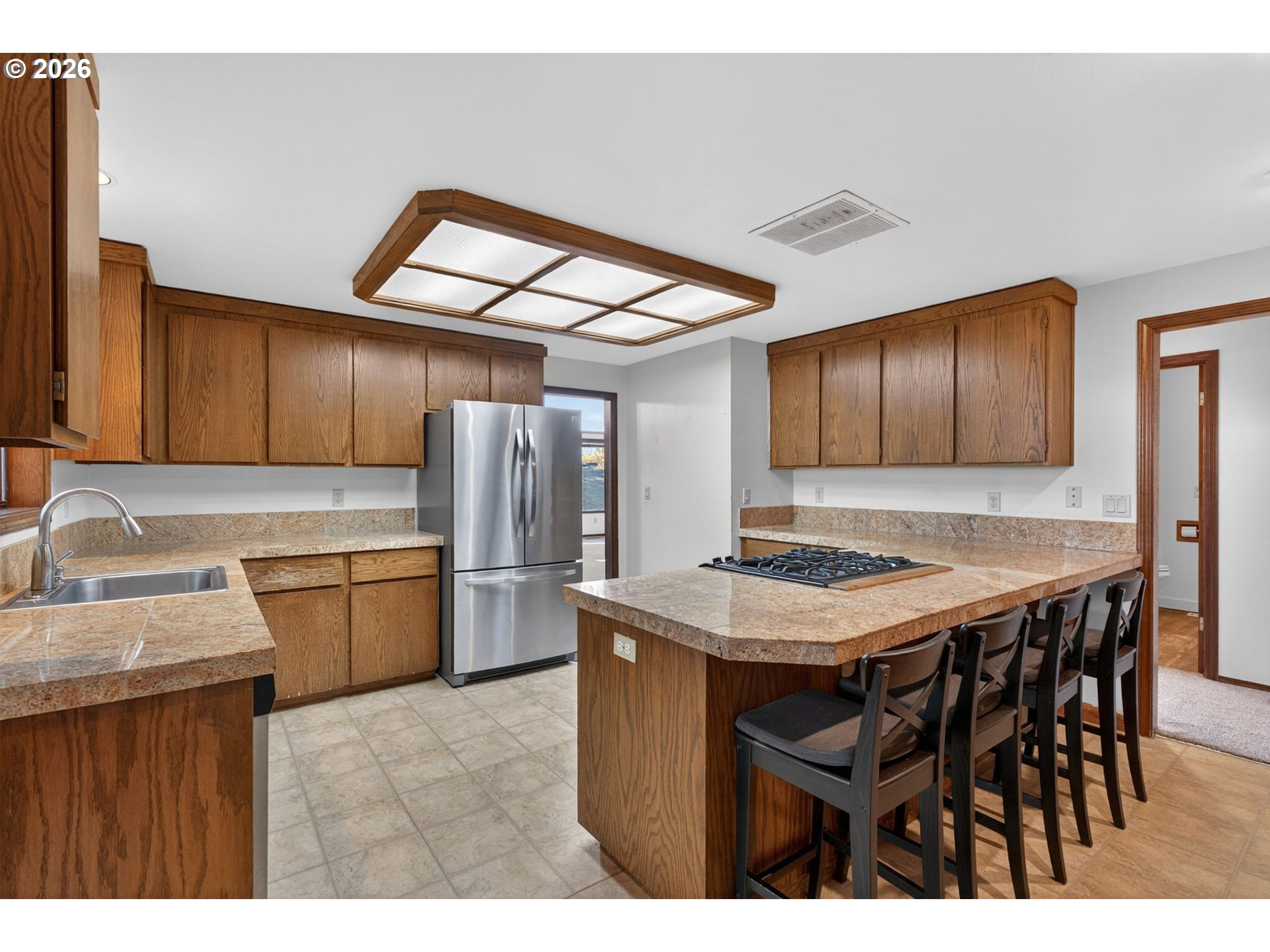 5205 Southwest 153rd Avenue Beaverton, OR 97007 - Photo 8 of 47 a kitchen with a table chairs refrigerator and microwave