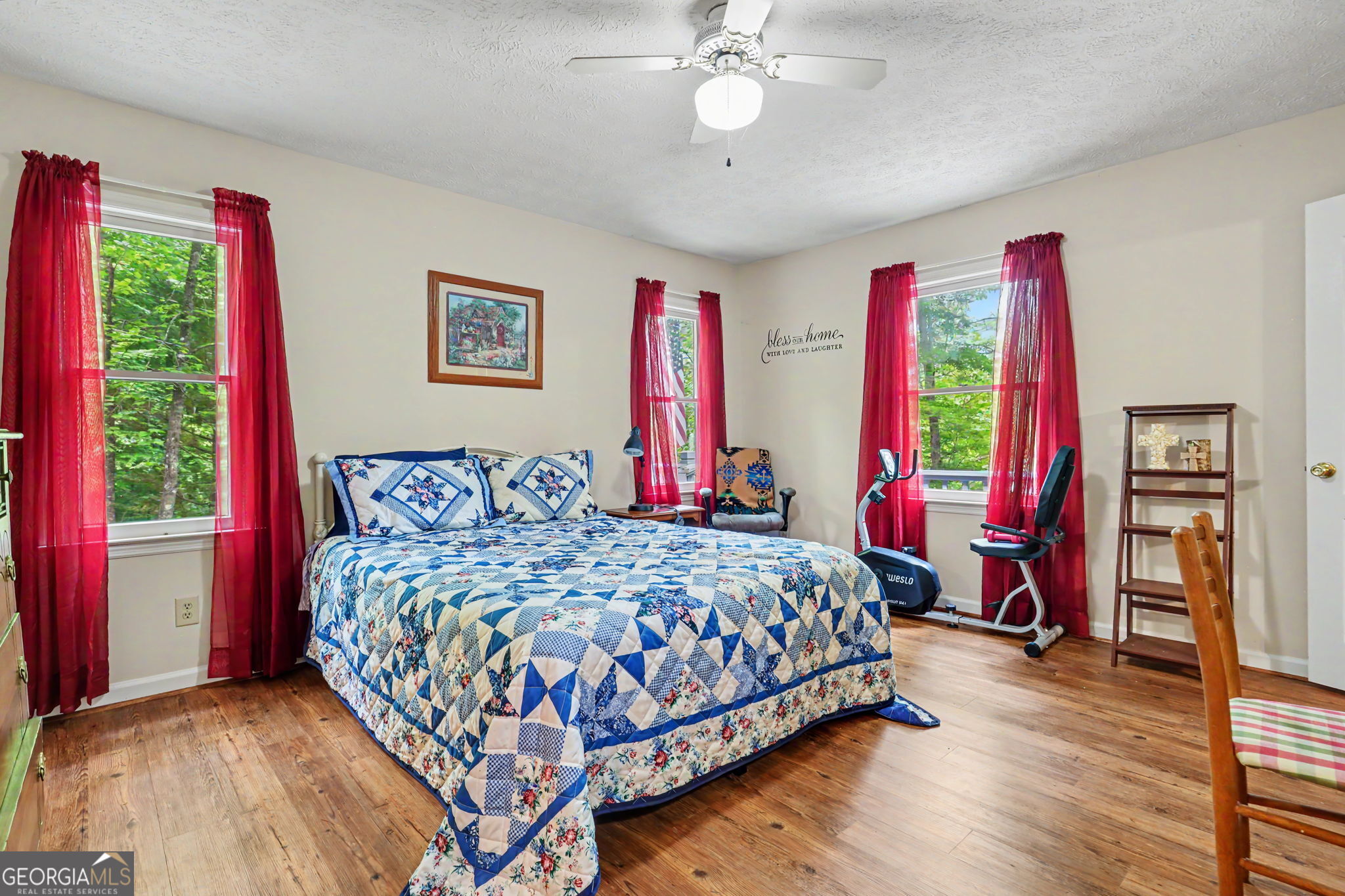 325 Walnut Mountain Road Rabun Gap, GA 30568 - Photo 14 of 38 a bedroom with a bed and a chandelier