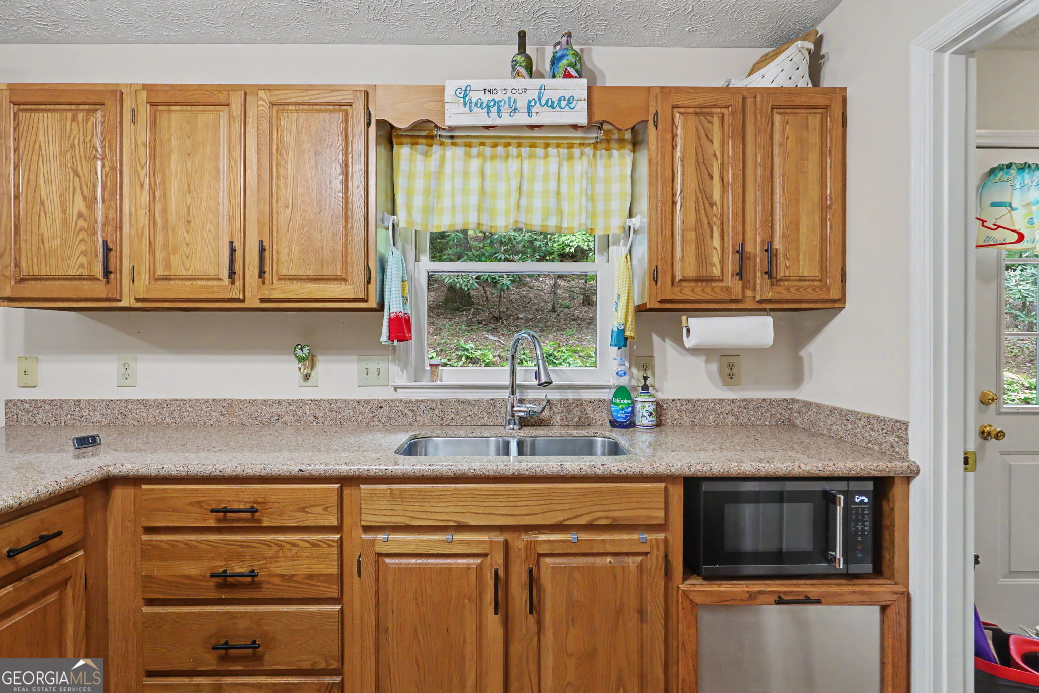 325 Walnut Mountain Road Rabun Gap, GA 30568 - Photo 19 of 38 a kitchen with stainless steel appliances granite countertop a sink a microwave cabinets and a window