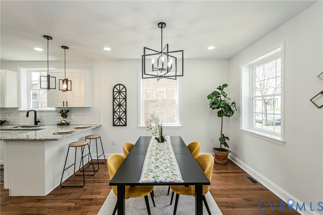 1400 Decatur Street Richmond, VA 23224 - Photo 14 of 49 a dining room with wooden floor a chandelier a wooden table and chairs