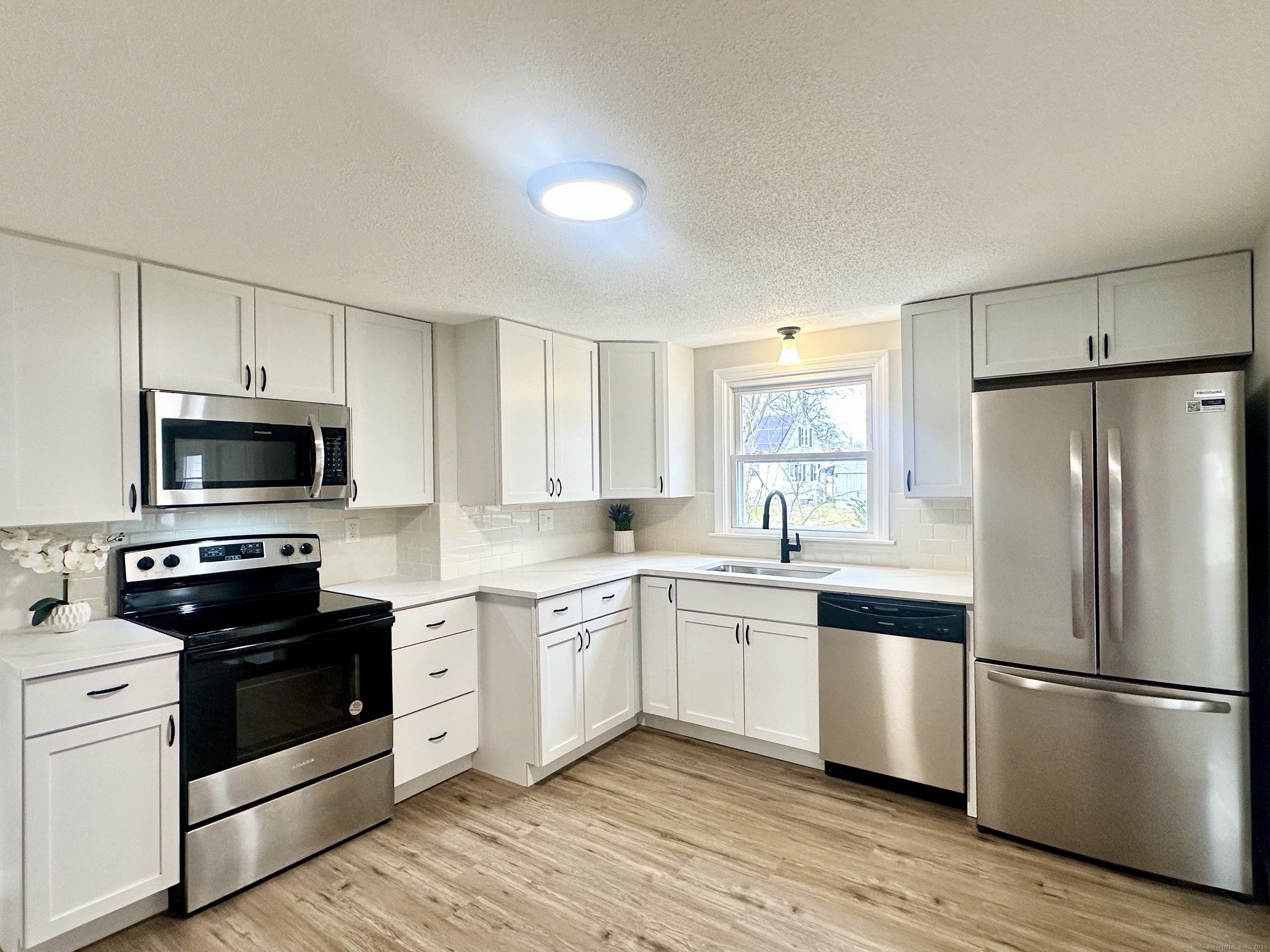 9 Eleanor Road Enfield, CT 06082 - Photo 12 of 32 a kitchen with white cabinets and stainless steel appliances