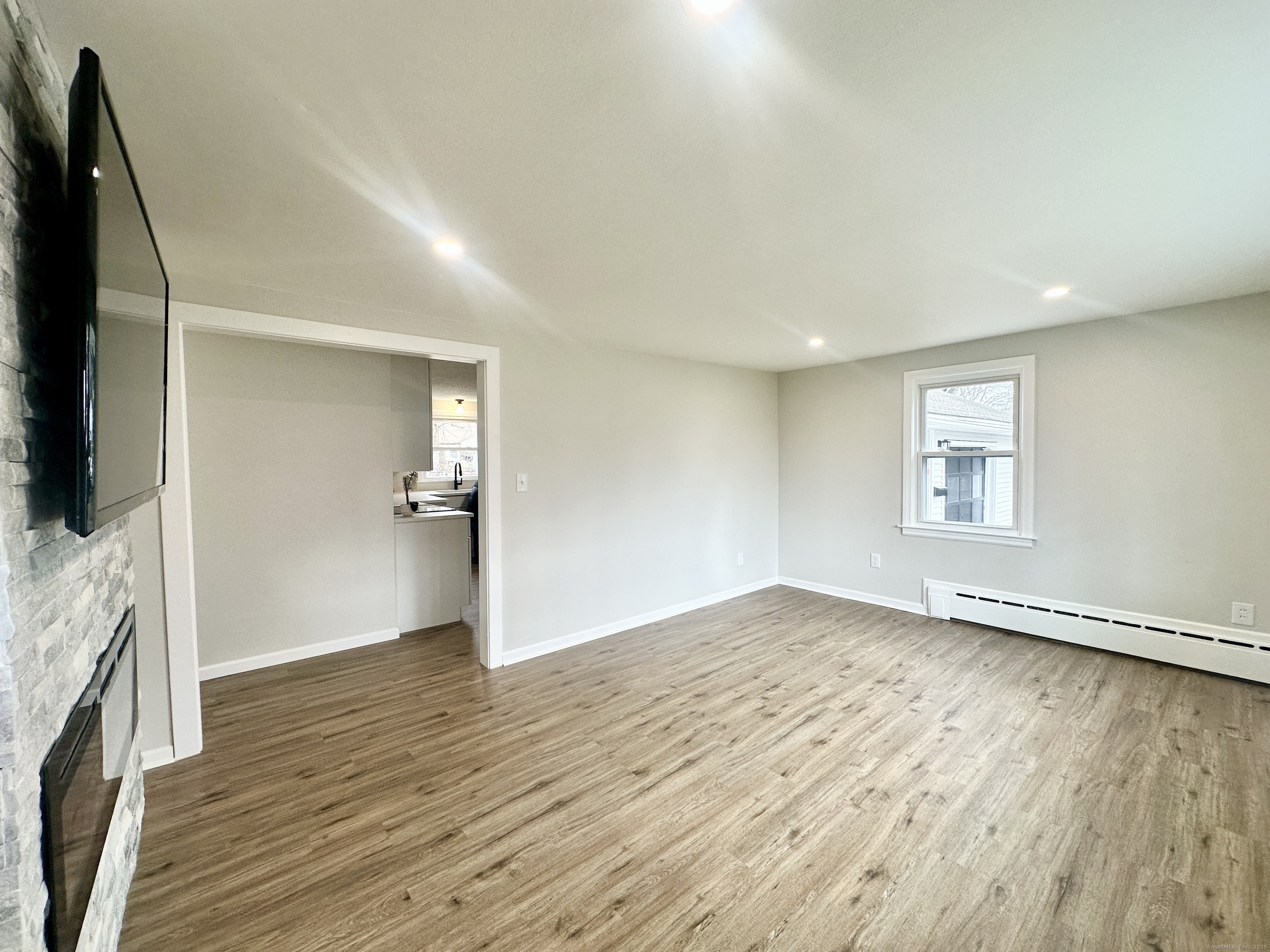 9 Eleanor Road Enfield, CT 06082 - Photo 16 of 32 an empty room with wooden floor and a flat screen tv