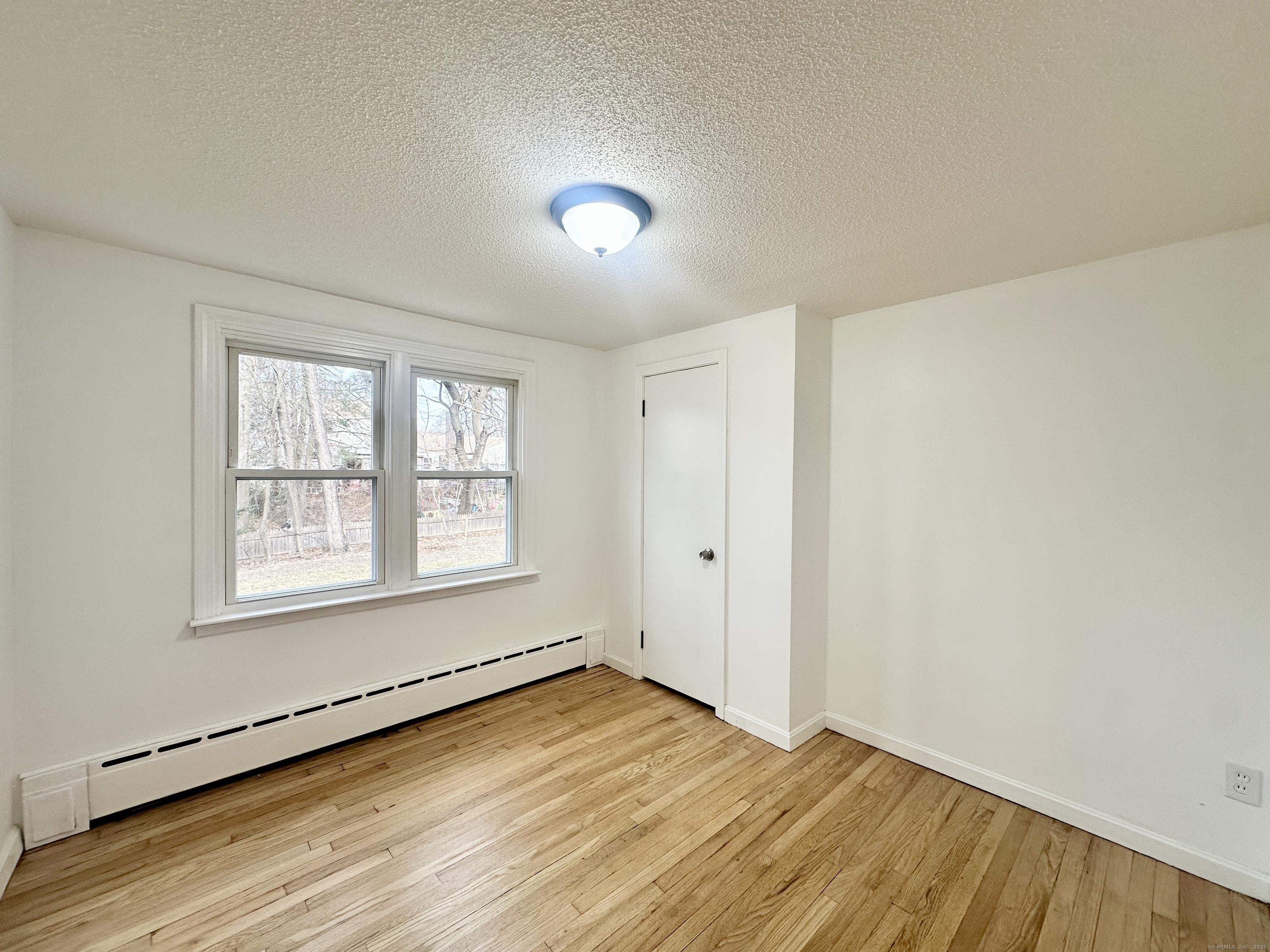 9 Eleanor Road Enfield, CT 06082 - Photo 21 of 32 a view of an empty room with wooden floor and a window