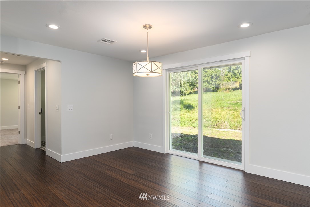 14425 Westwick Road Snohomish, WA 98290 - Photo 11 of 25 an empty room with wooden floor and windows