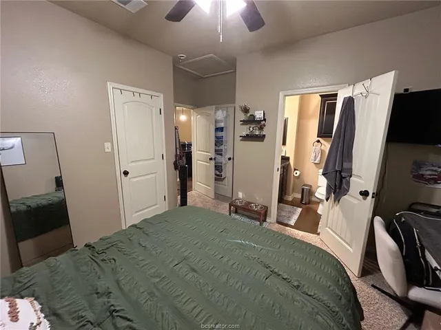 a bedroom with a bed and a flat tv screen on the dresser