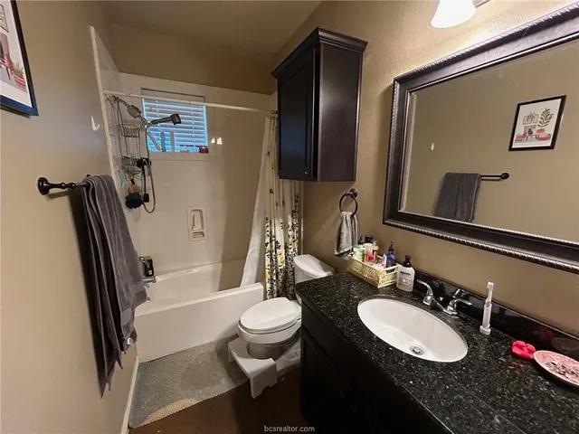 a bathroom with a sink a toilet a tub and shower