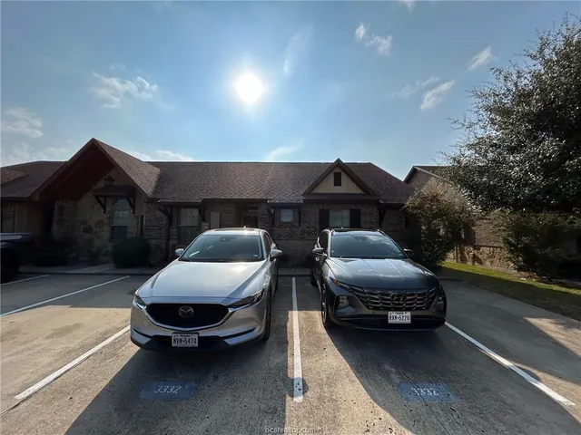 a couple of cars parked in front of a house