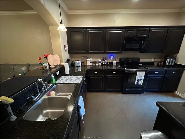 a kitchen with a sink and a stove top oven with wooden floor