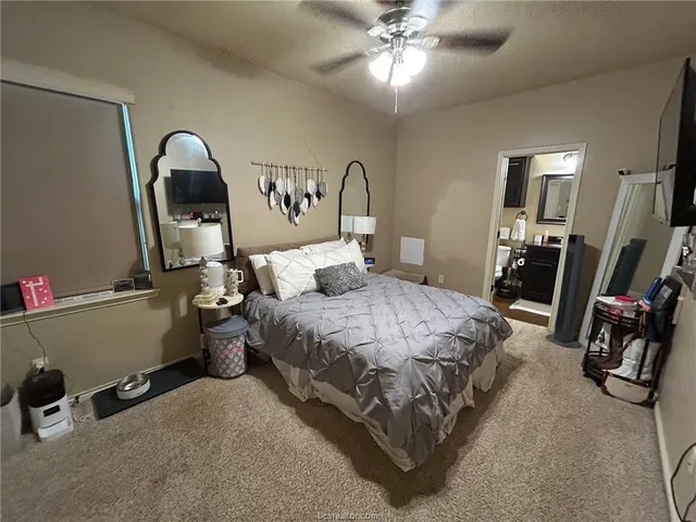 a bedroom with a bed a desk and mirror
