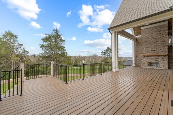 a view of a balcony with wooden floor and fence