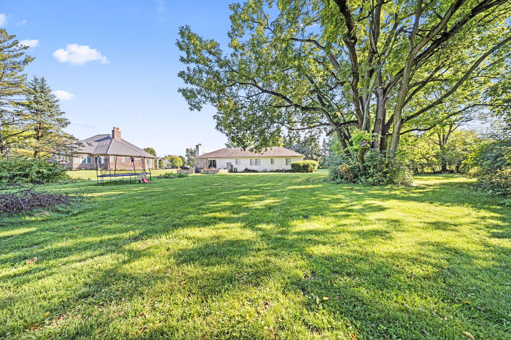 6344 Post Road Dublin, OH 43017 - Photo 33 of 45 Expansive green lawn with mature trees and a single-story residence