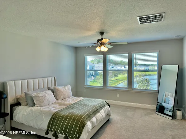 a spacious bedroom with a bed and a chandelier