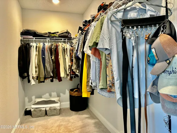 a view of walk in closet with clothes and shoes