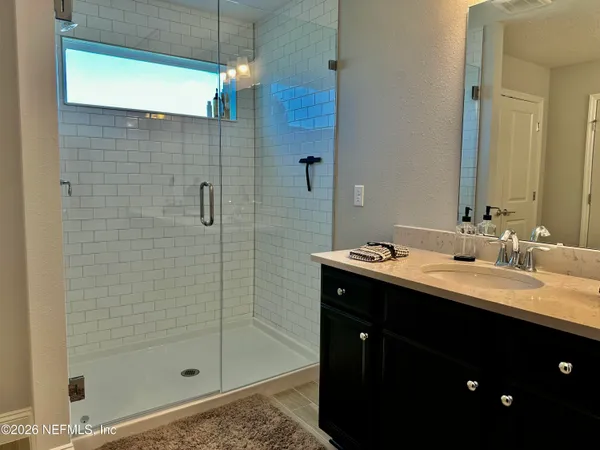 a bathroom with a shower sink and mirror