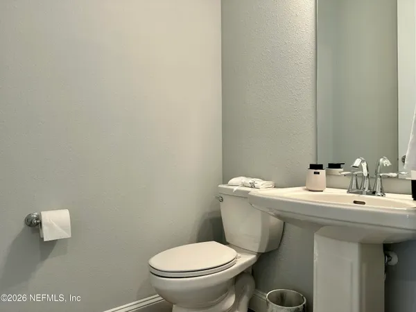a bathroom with a toilet a sink and mirror