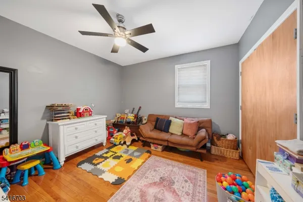 a living room with furniture and a baby crib with rug
