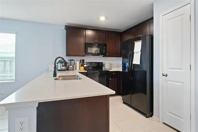 a kitchen with a refrigerator a sink and cabinets