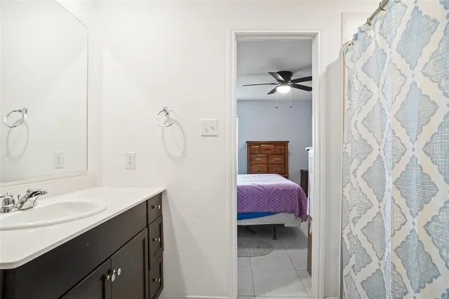 a en suite bathroom with a granite countertop sink and a mirror