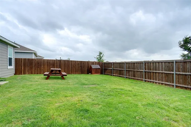 a view of a backyard with wooden fence