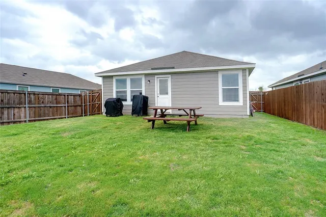 a backyard of a house with table and chairs