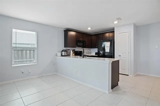 a kitchen with stainless steel appliances a refrigerator sink and microwave