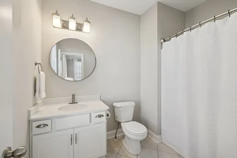 a bathroom with a toilet sink vanity and mirror