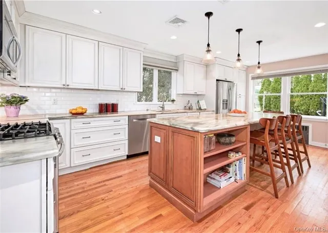a kitchen with stainless steel appliances granite countertop a stove and a wooden floors