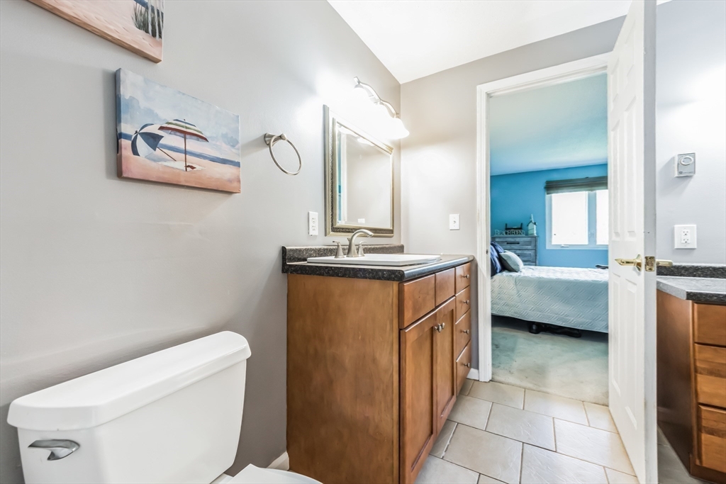59 Seabury, Unit 59 Hampton, NH 03842 - Photo 13 of 25 a bathroom with a toilet a sink and mirror