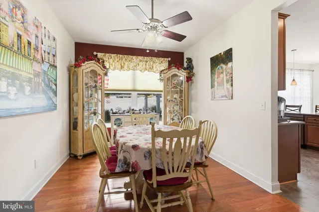a dining room with furniture a chandelier and wooden floor