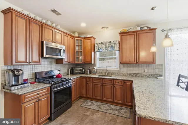 a kitchen with stainless steel appliances granite countertop a sink stove and microwave