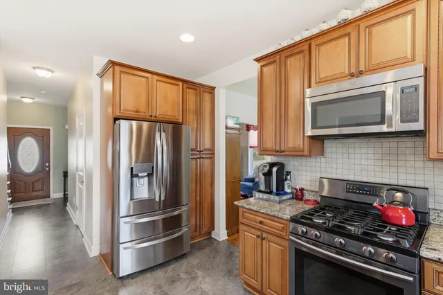 a kitchen with stainless steel appliances granite countertop a stove microwave and refrigerator