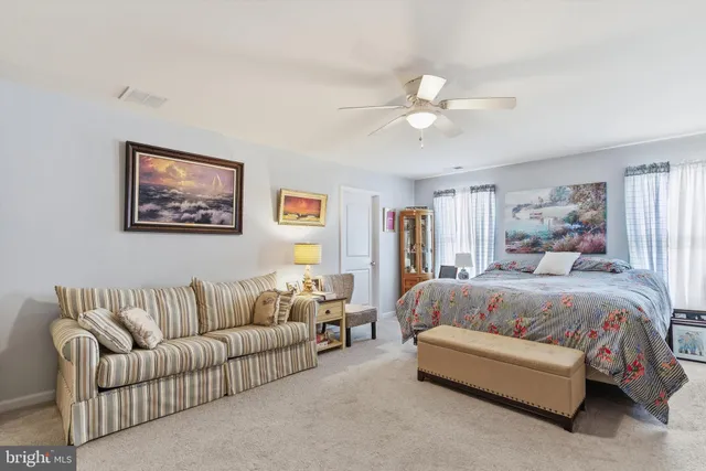 a spacious bedroom with a large bed couch and window