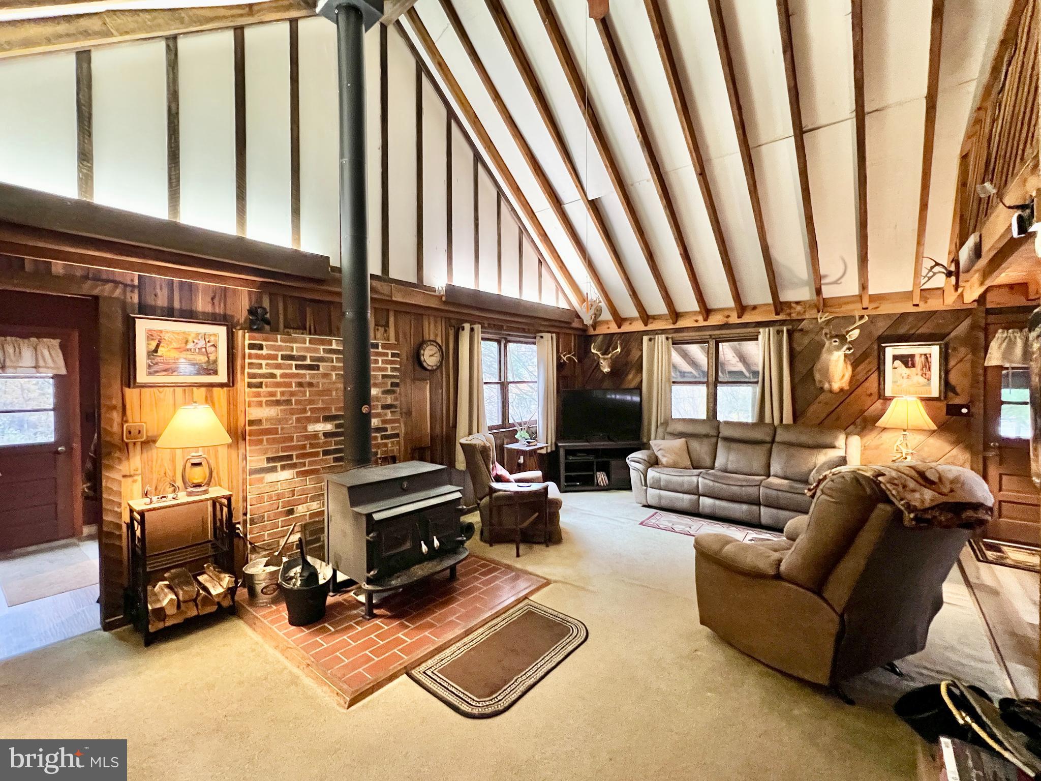 1858 Sandy Run Road Hopewell, PA 16650 - Photo 18 of 35 a living room with furniture a fireplace and large windows