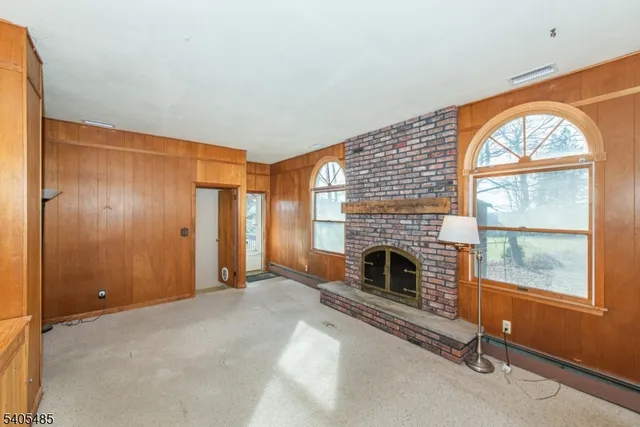 an empty room with windows and fireplace