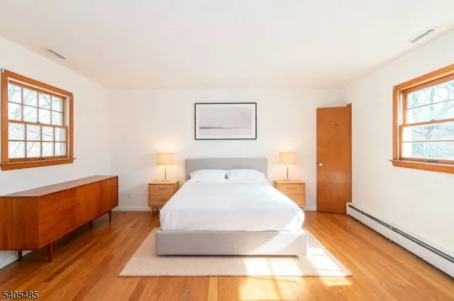 a spacious bedroom with a bed and wooden floor