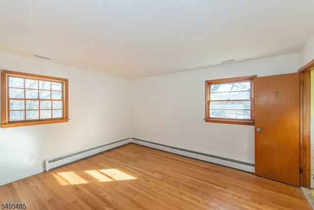 a view of a big room with wooden floor and windows in a room