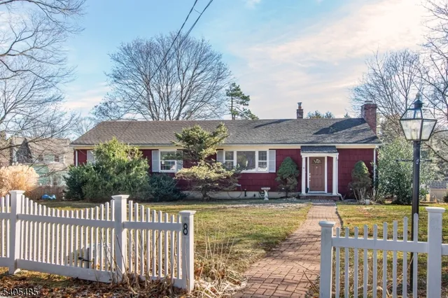 a front view of house with yard and trees in the background