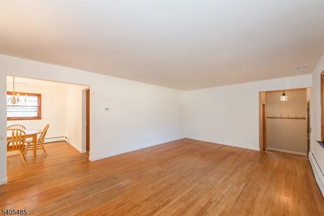 a view of empty room with wooden floor and chair