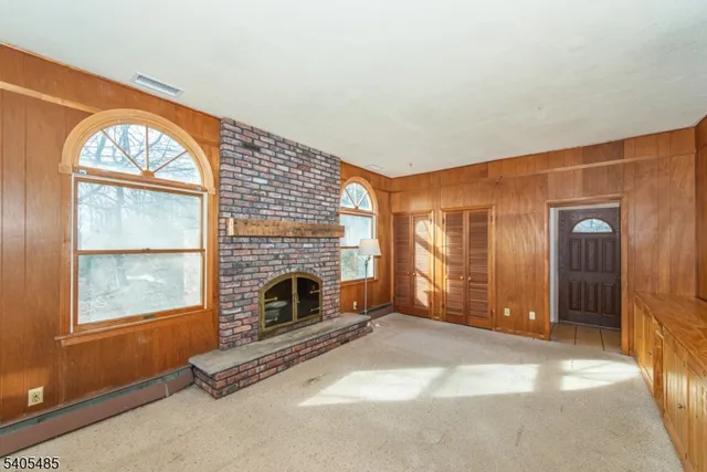 a view of an empty room with window and fire place
