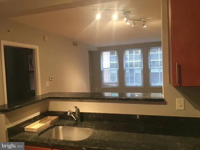 a view of a big room with wooden floor and windows