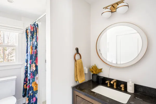 a bathroom with a sink mirror vanity and toilet