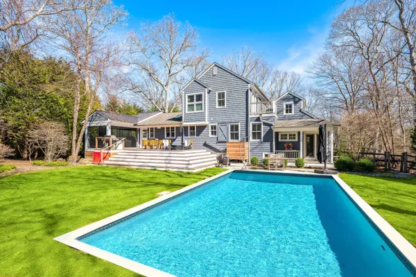 a view of a house with a big yard and large trees