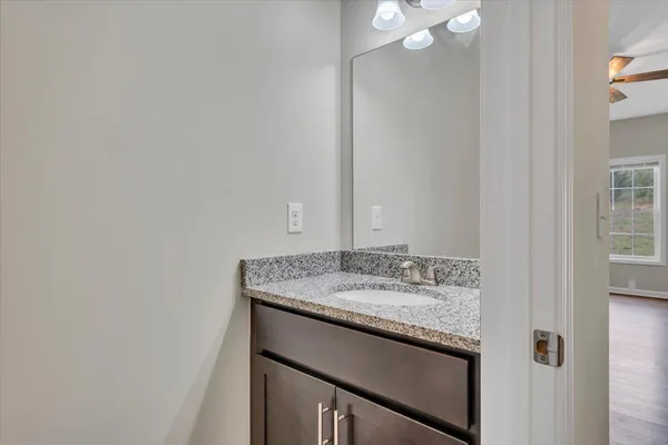 a bathroom with a granite countertop sink and a mirror