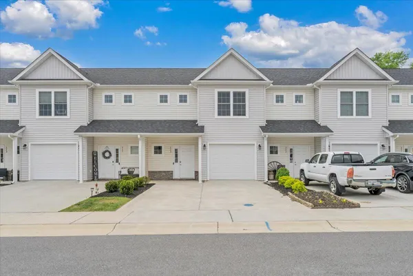 a front view of a house with a garden and parking