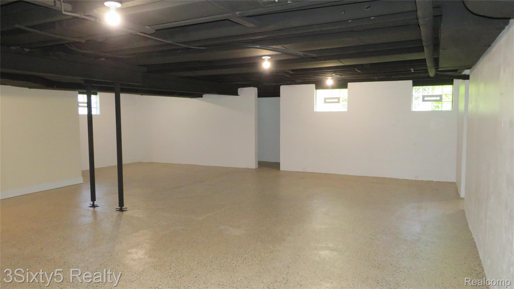 16558 Haggerty Road Belleville, MI 48111 - Photo 27 of 40 Finished basement featuring light-colored flooring, white walls, and exposed dark-painted ceiling joists