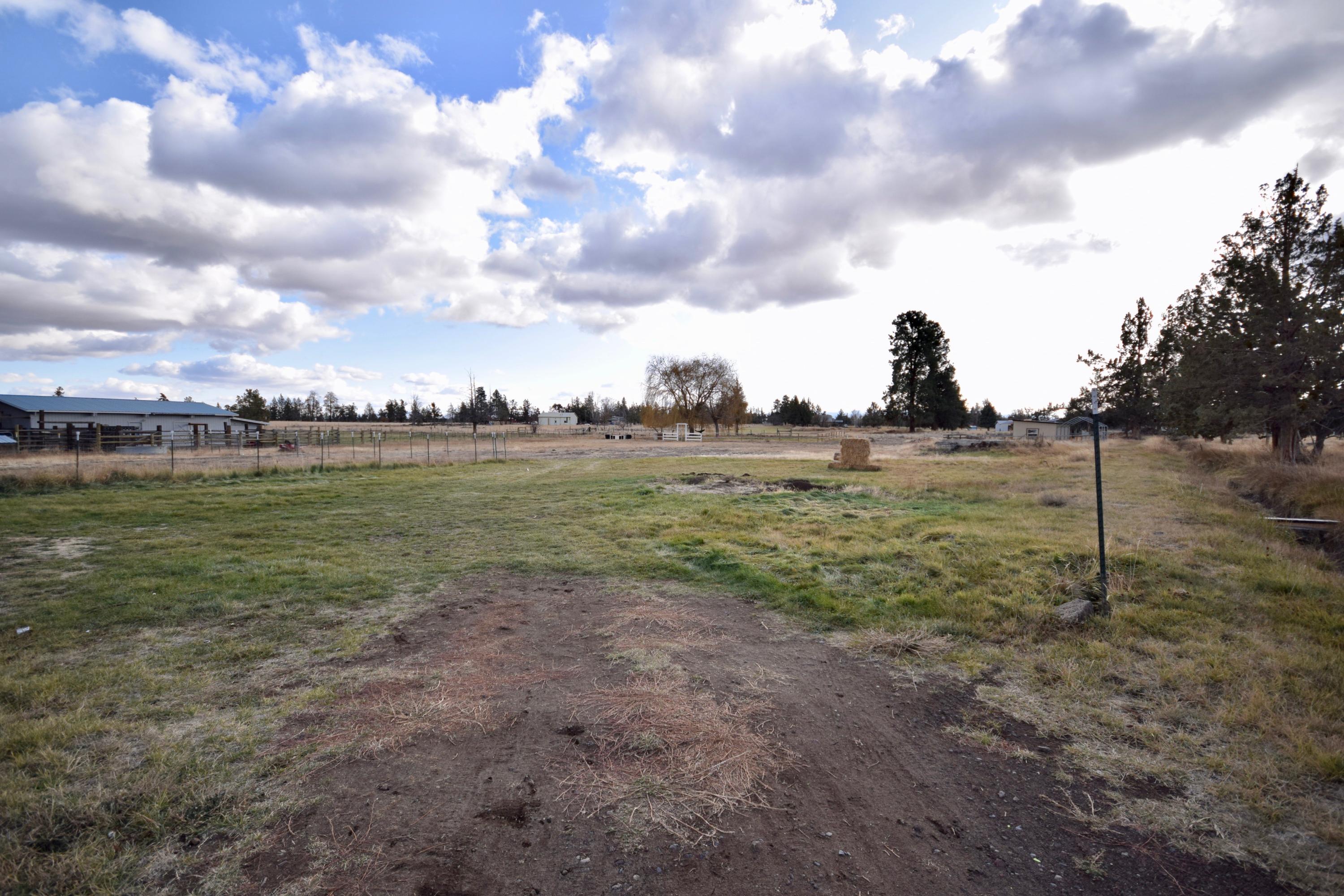 22169 Nelson Road Bend, OR 97701 - Photo 3 of 42 a view of a big yard with plants and a lake view